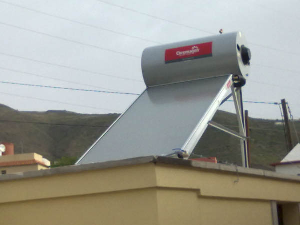 Sistema termosifón de energía solar térmica de Chromagen en azotea con vistas a las montañas
