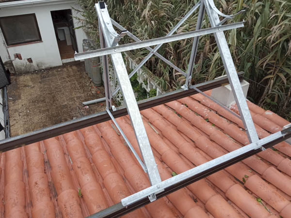 Instalación en proceso de placa de energía solar térmica en tejado de una casa rural particular