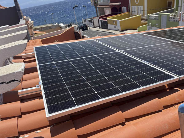 Paneles solares fotovoltaicos en tejado con vistas al mar