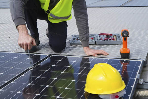 Profesional instalando un panel solar fotovoltaico junto a un set de herramientas